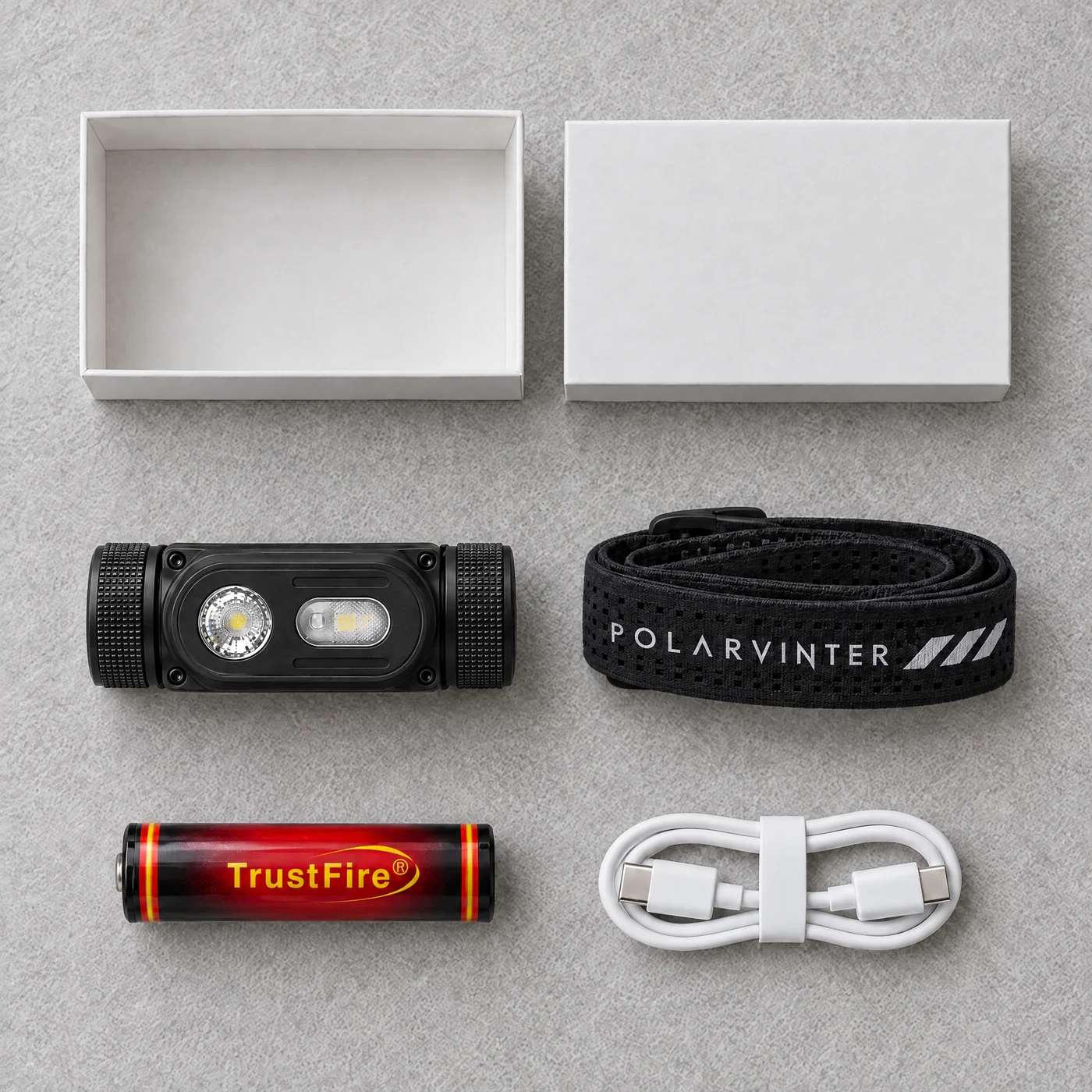 P1, pannband och USB-C-kabel bredvid en vit låda